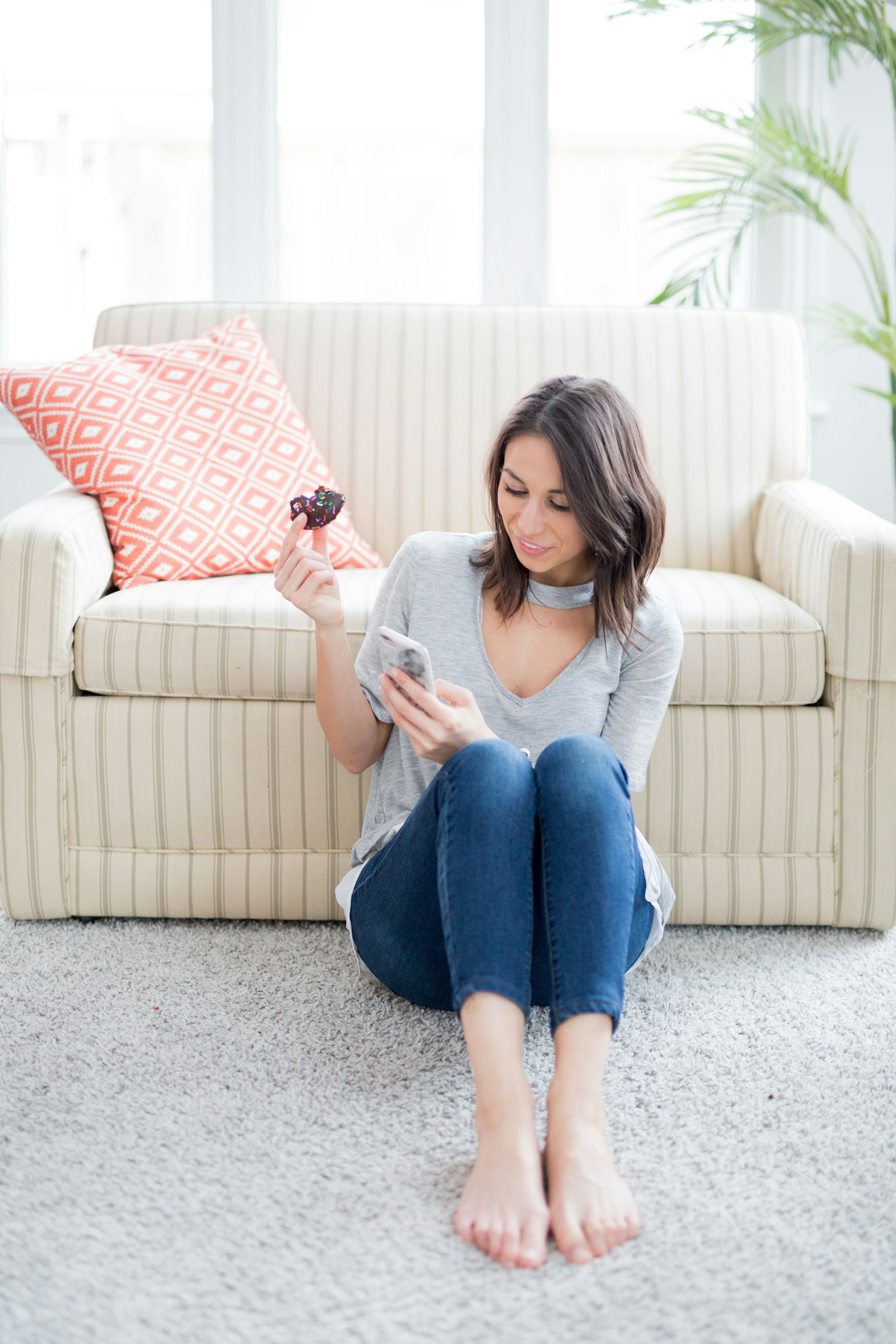 A woman smiling at her phone at home